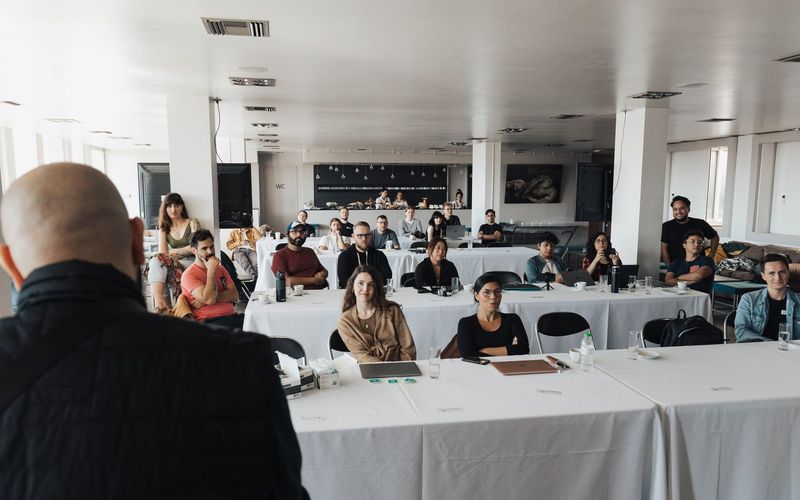 A speaker addressing a large room of seated professionals