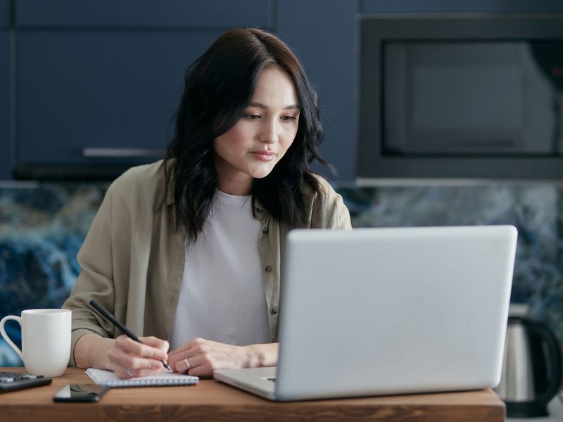 A professional working through a short online course at her kitchen table