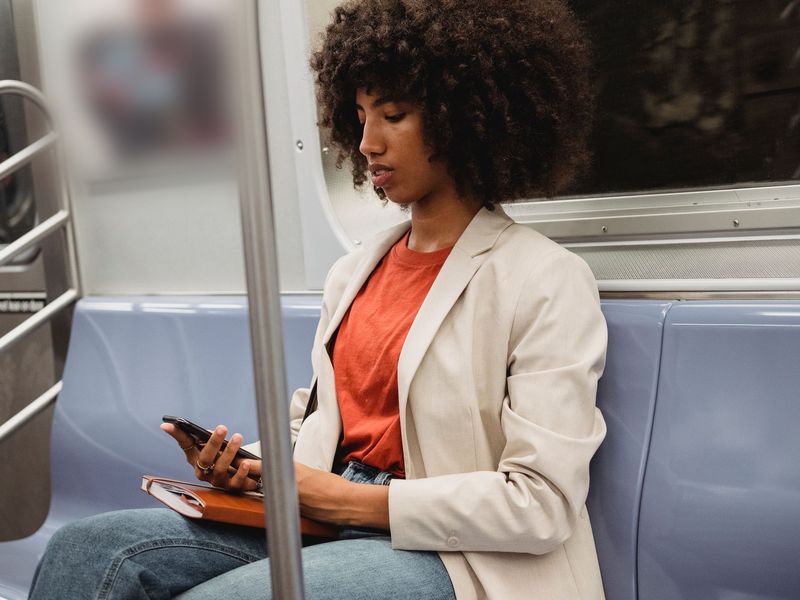A woman taking a course on her phone while travelling on a train